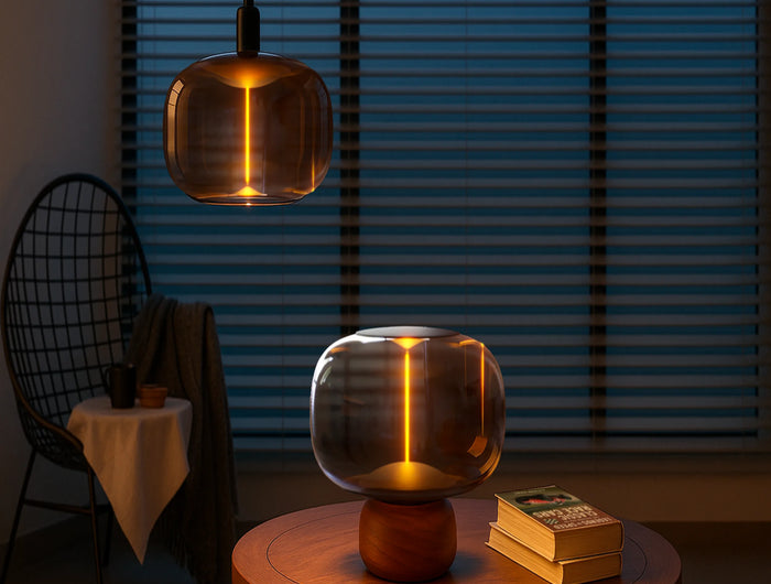 Modern pendant light fixture in a dimly lit room with a table and chair.