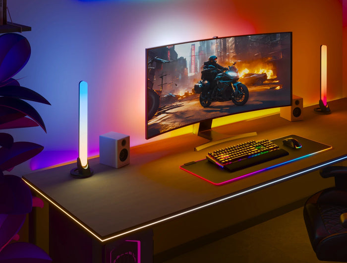 Gaming setup with a monitor, keyboard, and RGB lighting in a room.